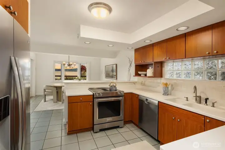 The kitchen is open to dining and living areas with a view of the lake.