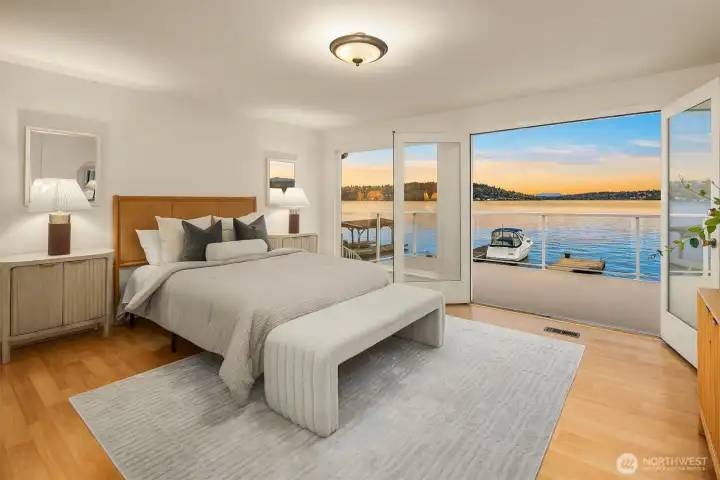 The primary bedroom, spacious & light filled, opens onto a striking panorama blending water, islands and Eastside shorelines and in the far background Mt Baker snowy peak.