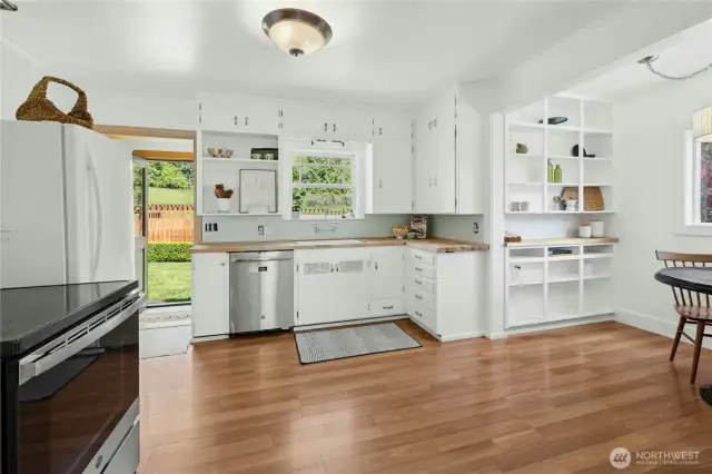 The light and airy kitchen has lots of open shelving and an original dropdown ironing board.