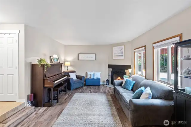 Living room with new floors, new paint, and a fireplace.