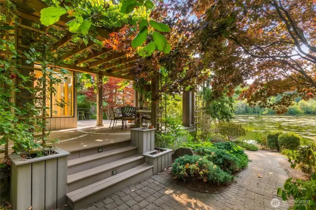 The composite deck wraps around the sunroom area with paved pathways curving through the area at the back of the home.