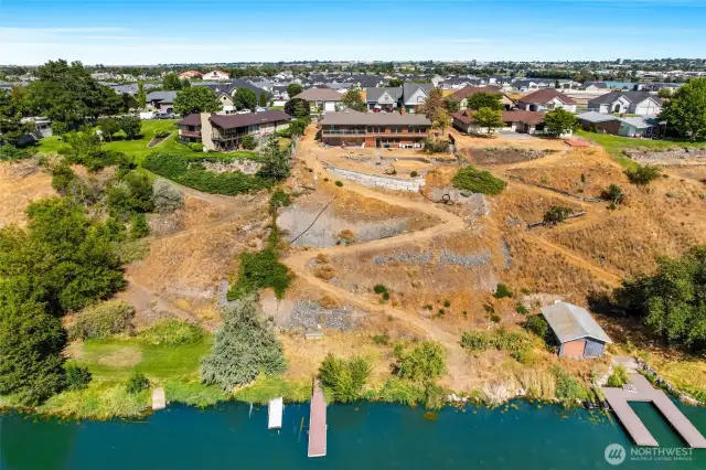 From the lake side, you can see the easy access by switchback down the hill on this high-bank property, down to the docks!