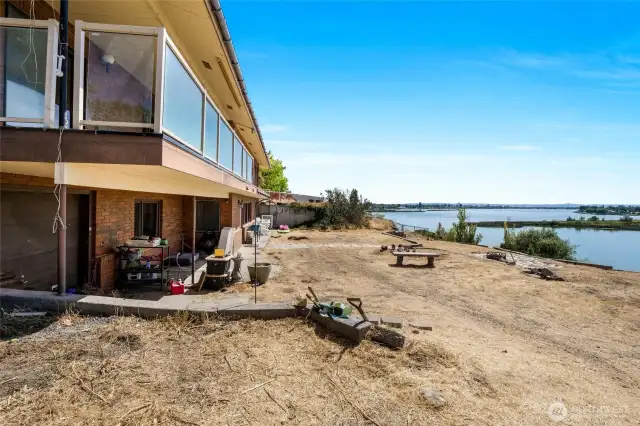 The backyard has been cleared of all the weeds, and now you can put in grass or parking. The garage is to the left, and there is a covered patio below, thanks to the main floor covered deck! Still have a great view of the lake from the bottom floor.