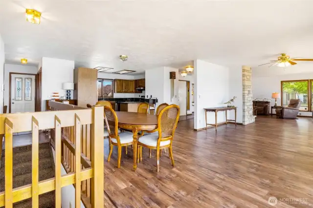 Here is your dining area, large sitting area for viewing the lake, kitchen in the background, and the living room with a fireplace in the background to the right.  Windows are all around and WHAT a view!  Sliding glass doors to the deck are behind you in this photo.