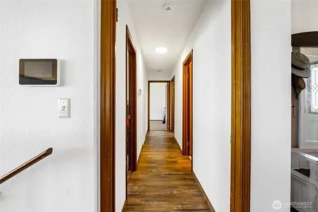 Hallways to the main floor bedrooms, bathrooms, utility room, and garage access.
