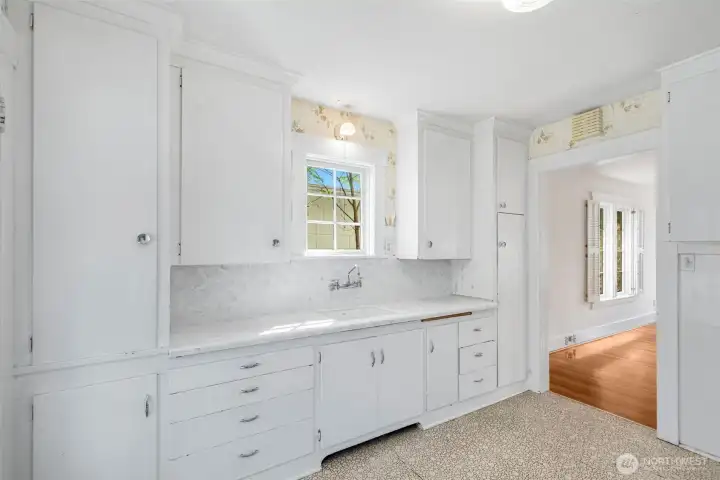 A charming, vintage, country kitchen anchors the back corner of the home.
