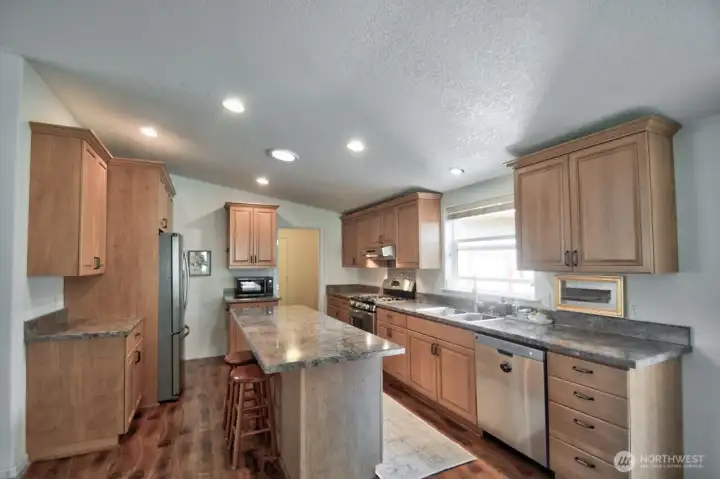 Kitchen with Island eating bar, tons of cabinets and drawers.