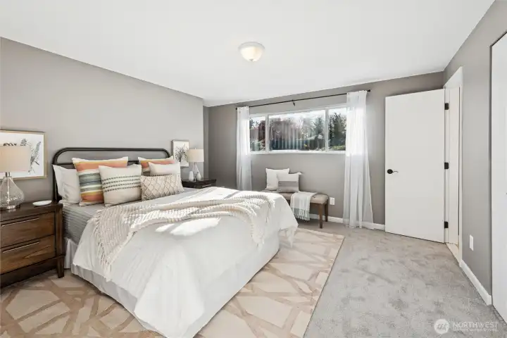 Ensuite 2nd bedroom opposite primary bedroom has larger window with southern exposure. Corner door opens to the bathroom.