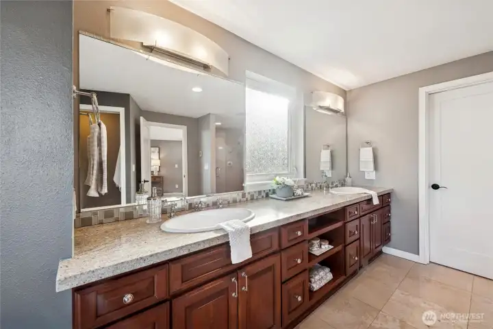 and large double vanity with drawers, shelves and rain glass window dividing the sides.  Door in back of the photo leads to the walk-in closet with new closet system by Closets by Design.