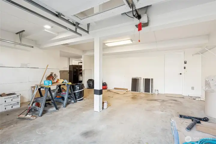 Double oversize garage has plenty of space for cars and workbenches.  OPening on left side is to the additional storage garage space.