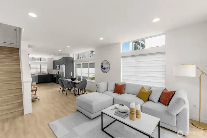 A sunlit great room framed by wide plank floors and clean finishes offers modern elegance.