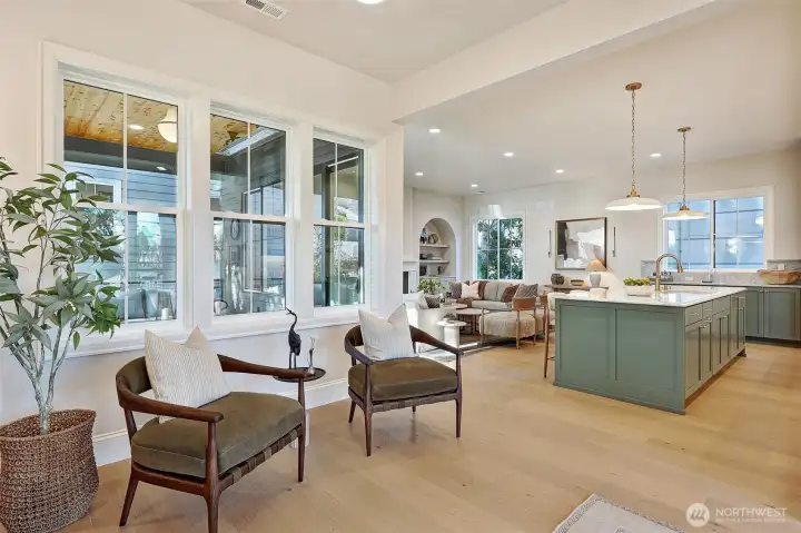 Natural light fills every space as it pours in through abundant windows, highlighting 10-foot ceilings and engineered hardwood floors throughout the main level.