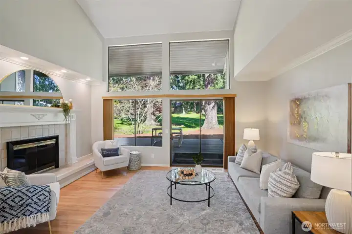 Formal living room with floor to ceiling windows, gas fireplace with tile surround and ornate wood detailing