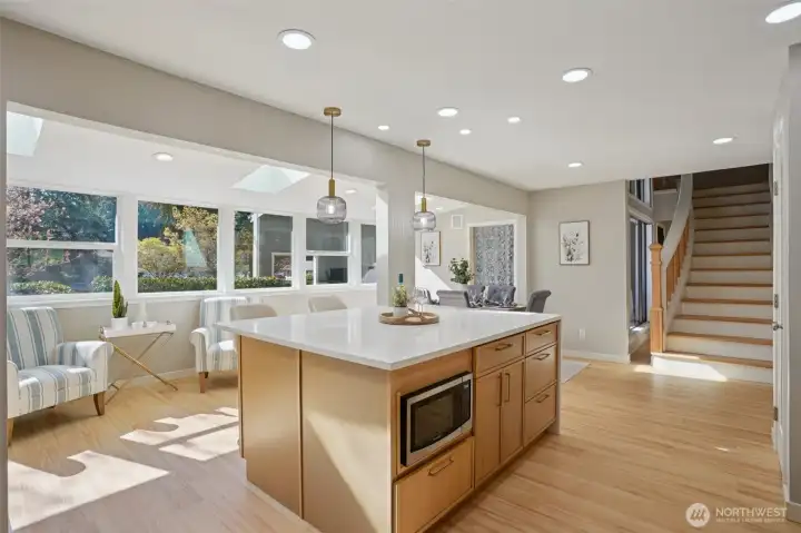 Behind island is a light filled coffee bar with views of the front of the house