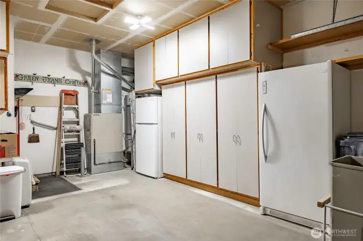 Attached 2-car garage features built-in cabinets & shelves on all the walls inside garage.