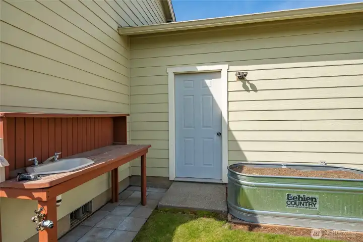 Backyard gardening table with sink and water hookup. (can be removed if not wanted) Door leads into garage.