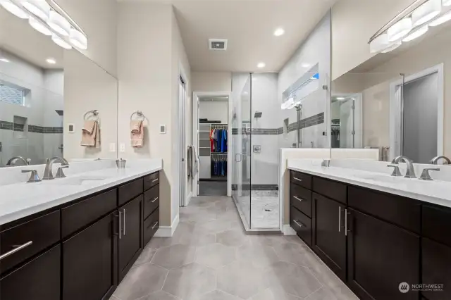 Indulge in the luxurious primary en-suite, boasting dual vanities for effortless morning routines, a spacious shower with dual shower heads for a spa-like experience, and a private water closet for added convenience and privacy.