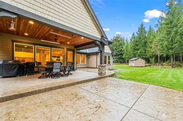 The backyard features a covered porch, thoughtfully designed with recessed lighting, an outdoor fan, and heaters for year-round comfort.