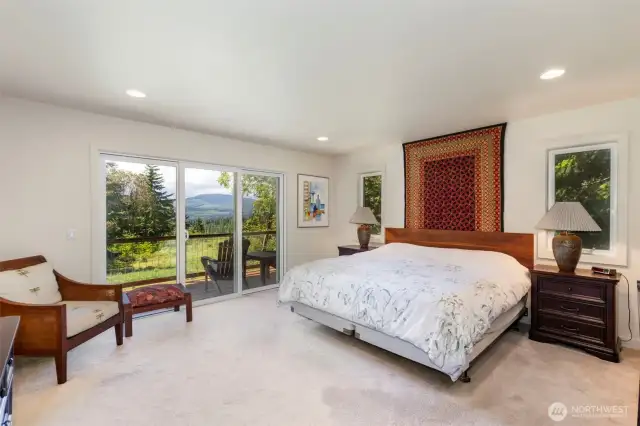 To the left towards the view is the primary with walk in closet, bathroom with tiled walk in shower, tiled, heated floors and soaking tub with a view.