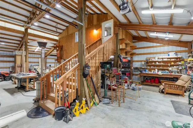 Inside the shop there is ample light and insulation.  Building has its own 200 amp service, three roll up doors, one 14 feet tall.  Up the stairs is the guest room.