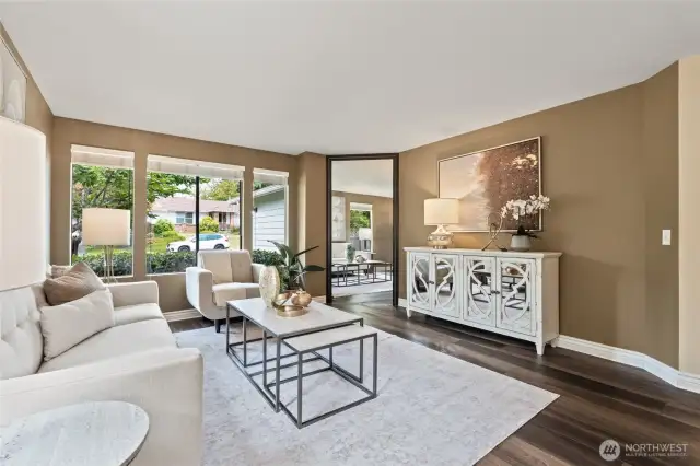 Large living room with luxury vinyl flooring and lots of windows inviting the natural light inside.