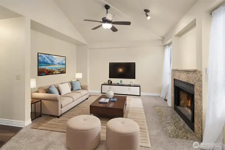 Love this family room with vaulted ceilings, ceiling fan, cozy fireplace, and windows with peaceful views of the backyard. (Digitally staged).