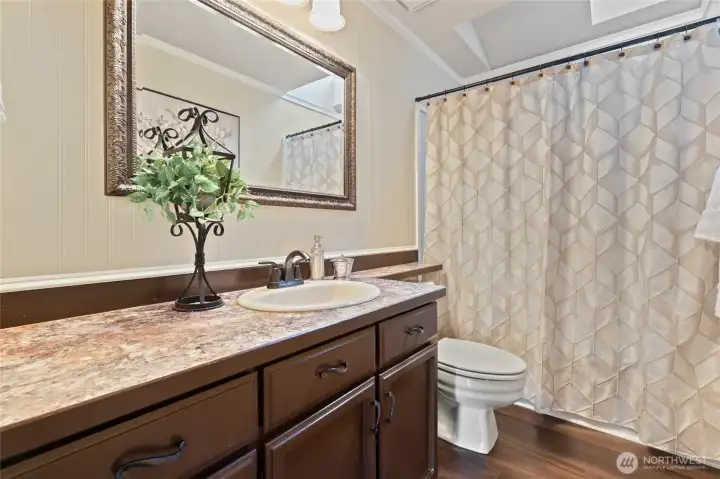 Full bathroom on main floor with shower/tub and plenty of cabinet and counter space for guests or family.