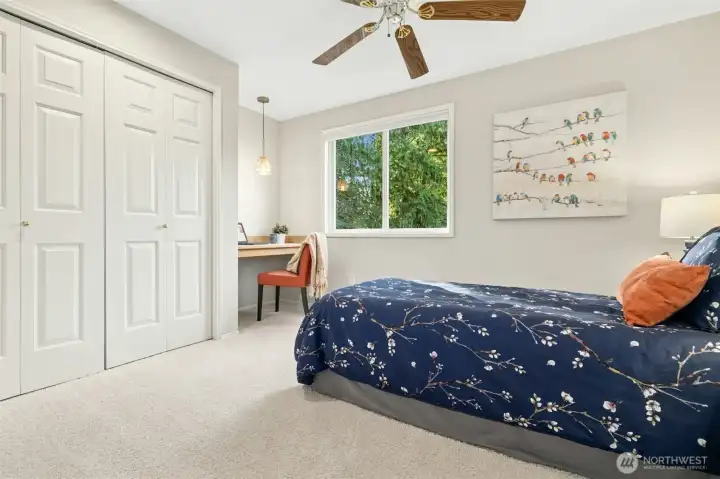 Guest room with a ceiling fan and a built-in work station.