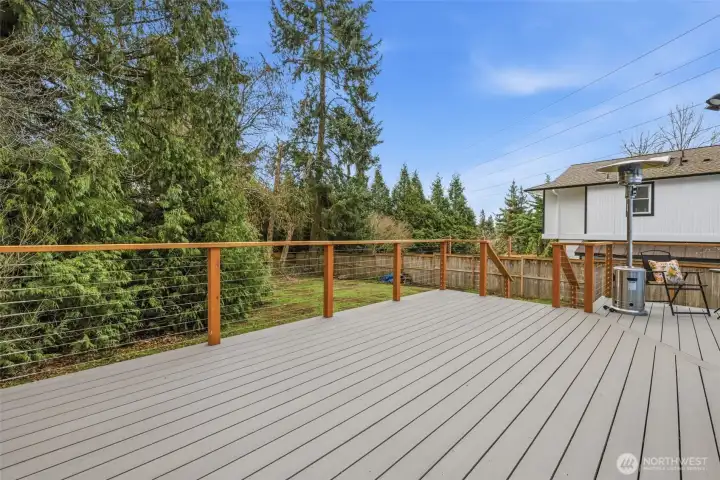Oversized Trex deck offering plenty of space for outdoor dining, entertaining, and relaxing, all overlooking a private backyard.