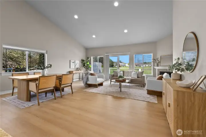 Living room with fireplace, large windows, and open sightlines across main living area