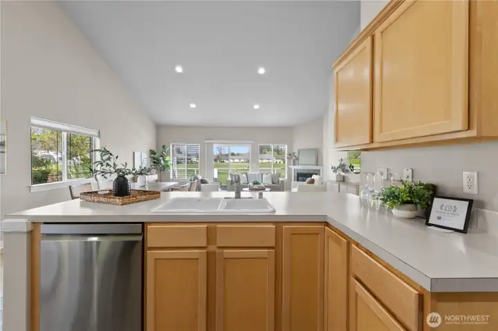 Open kitchen layout with breakfast bar seating and connection to dining and living areas