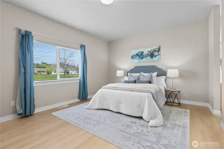 Primary bedroom with generous floor space, large window, and neutral finishes