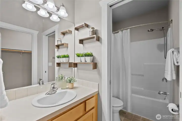 Bathroom with vanity storage, mirror, and tub/shower combination