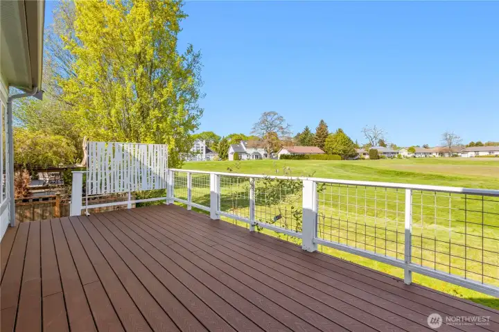 Rear exterior with deck access and open greenbelt backdrop.