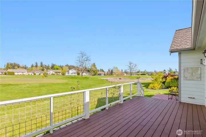 Elevated rear view highlighting open greenbelt and nearby pond within the golf course setting.