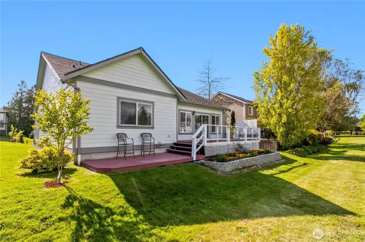 Flat and open backyard surrounded by greenspace.