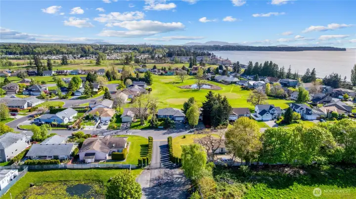 Aerial perspective showcasing the community layout, golf course, and coastal setting.