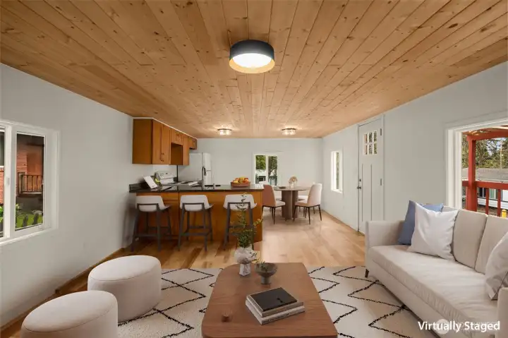 Virtually staged photo of living room and kitchen space.