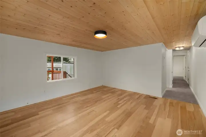 Another view of the spacious living area leading into the hallway and bedrooms beyond.