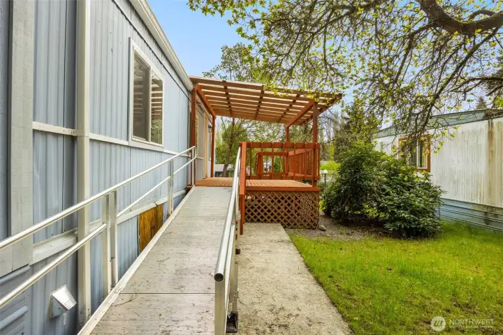 Gently sloped, aluminum ADA-accessible ramp leading to the covered deck and front entrance.