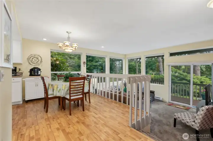 Large windows fill the living and dining areas with natural light while showcasing peaceful views of the surrounding trees. Large windows fill the living and dining areas with natural light while showcasing peaceful views of the surrounding trees.