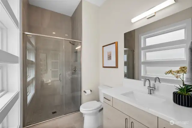 The oversized ceiling height makes the space feel larger.  Upgraded glass shower doors adorn the shower and provide a glimpse of the detailed tile work.
