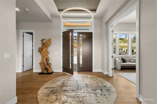 A lustrous entry offers a simple elegance that will have your eyes sweeping the home in awe.  From the inlaid ceiling decor to the wide planked engineered hardwoods, each detail compliments the home to create a beautiful space that feels warm and inviting.