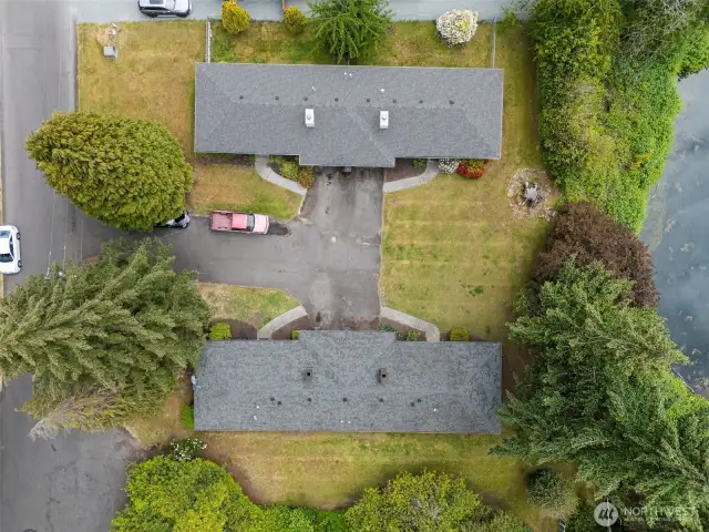 Aerial of the entire property showing green space and all four units.
