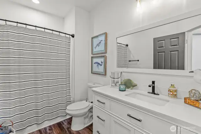Main full bath wtub/shower, comfort height toilet and vanity. Quartz countertops, new faucet, large mirror and bright fixtures.
