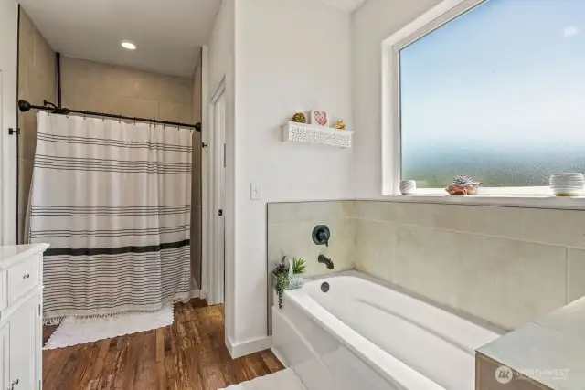 Obscured window, separate tub w/tile surround, tiled in, oversized shower and walk-in closet.
