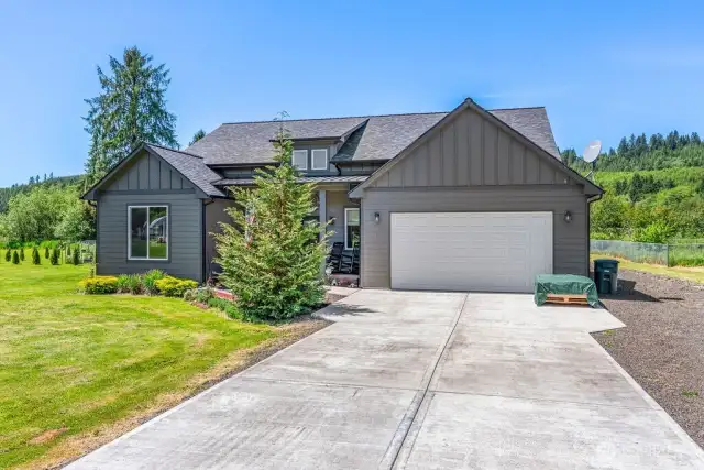 Concrete driveway with ample parking, rocked area for RV or extra parking.