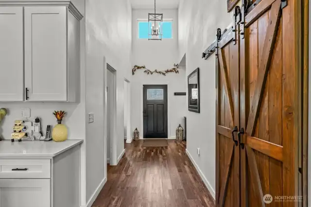Heading toward the front door, spy those high ceilings and clerestory windows - and off course those custom made barn doors!