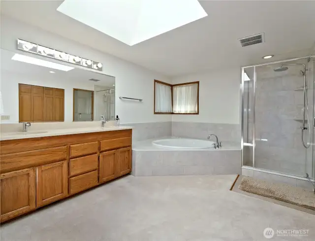 Brand new deep soaking tub and glass shower in primary suite bathroom