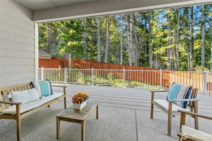 Covered patio overlooks the fenced backyard.
